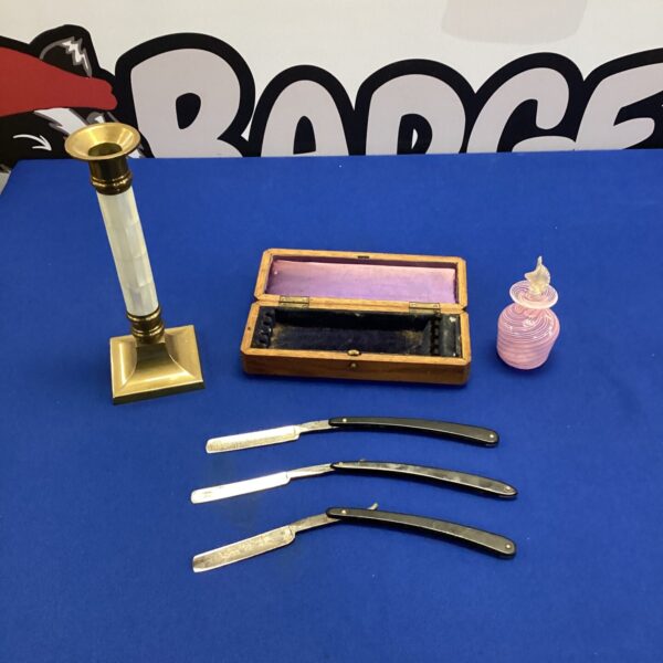 Vintage razor collection with candlestick and scent bottle.