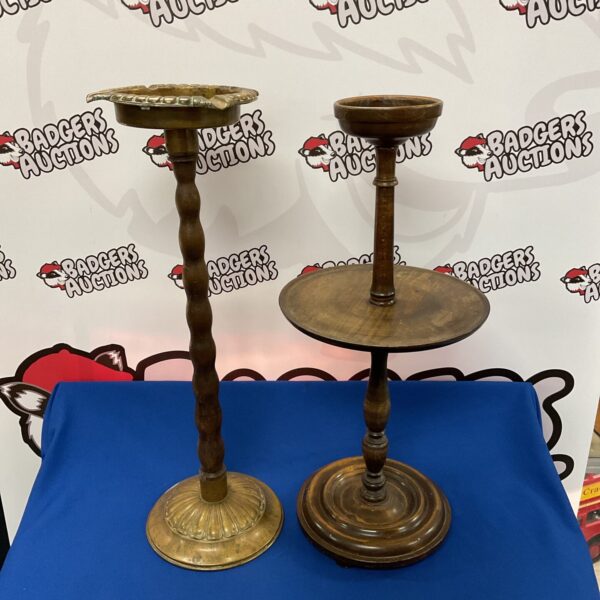 Pair of vintage brass pedestal ashtrays on display.