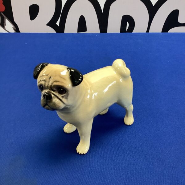 Detailed ceramic pug dog ornament for home decor.