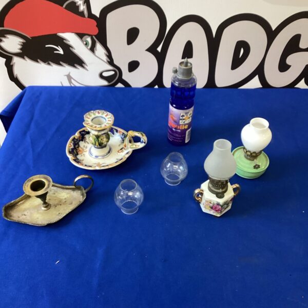 Vintage miniature oil lamps and candle holders on a blue surface.