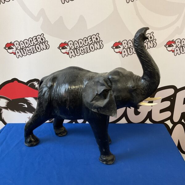 Detailed vintage leather elephant sculpture with tusks.