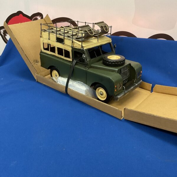 Vintage tin Land Rover model in original box, collectible toy.