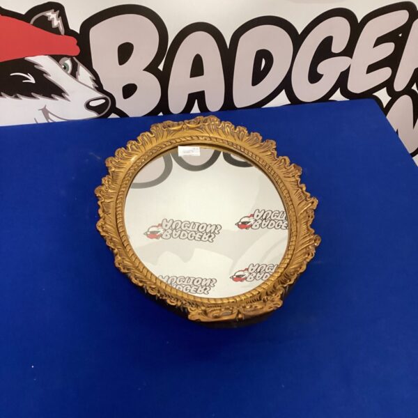 Gold framed oval mirror for wall decoration.