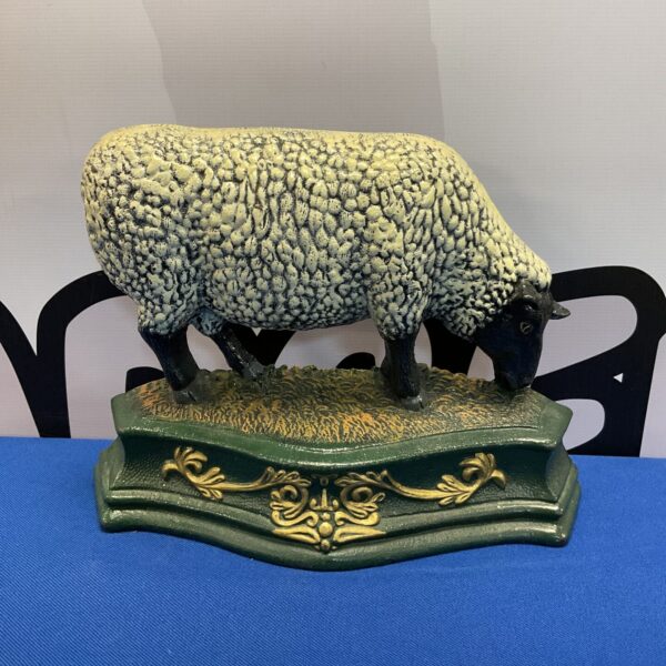 Antique cast iron sheep doorstop for farmhouse decor.