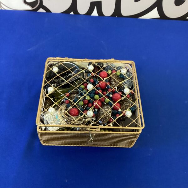 Woven basket filled with colourful vintage costume jewellery.