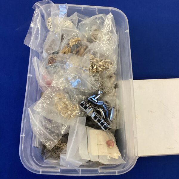 Clear plastic box filled with a costume jewellery lot.