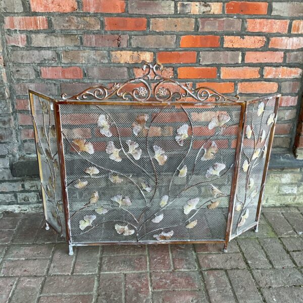Vintage cast iron firescreen with bird and vine design.