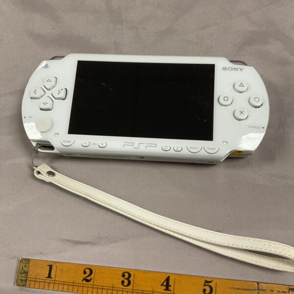 White Sony PSP 1000 handheld gaming console, vintage condition.
