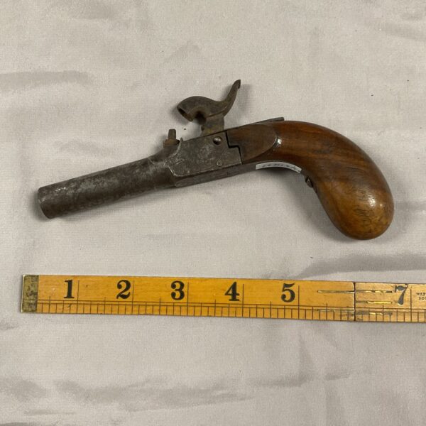 Antique black powder pistol with wooden stock and metal barrel.