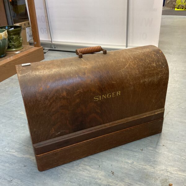 Dark wooden vintage Singer sewing machine case with a locking mechanism.