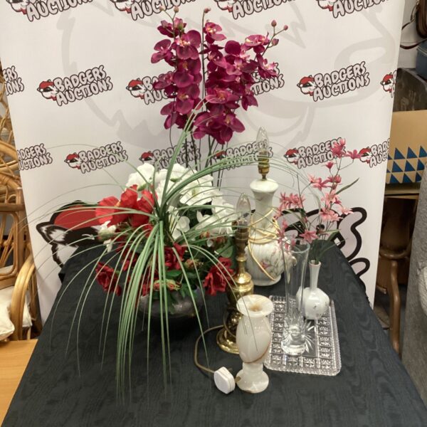 Vibrant artificial flower arrangement with vintage brass table lamp.