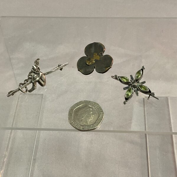 Vintage silver brooches with floral designs, collectible jewellery.