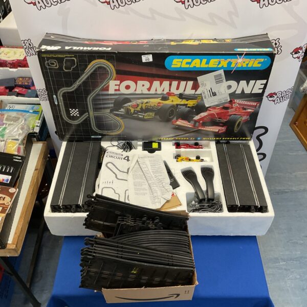 Vintage Scalextric Formula One racing set with box and track pieces.