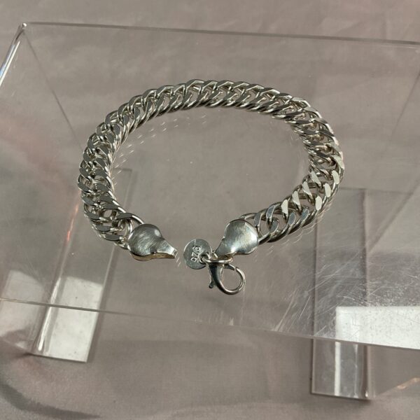 Close-up of a 925 silver curb chain bracelet with a secure clasp.