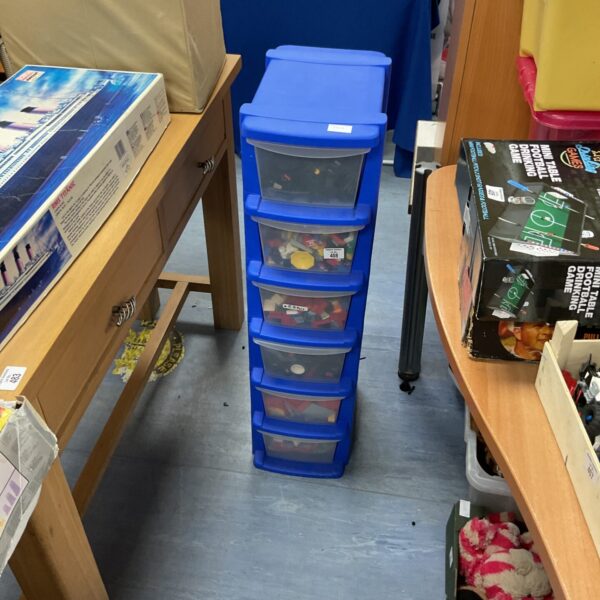Six-draw plastic storage crate filled with mixed Lego bricks.