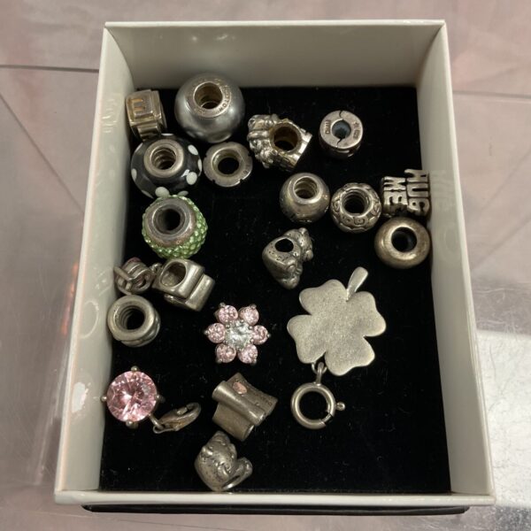 Diverse collection of silver-tone bracelet charms for jewellery making.