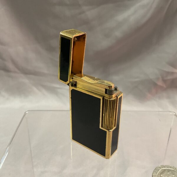 Open vintage Dupont gas lighter with gold accents.