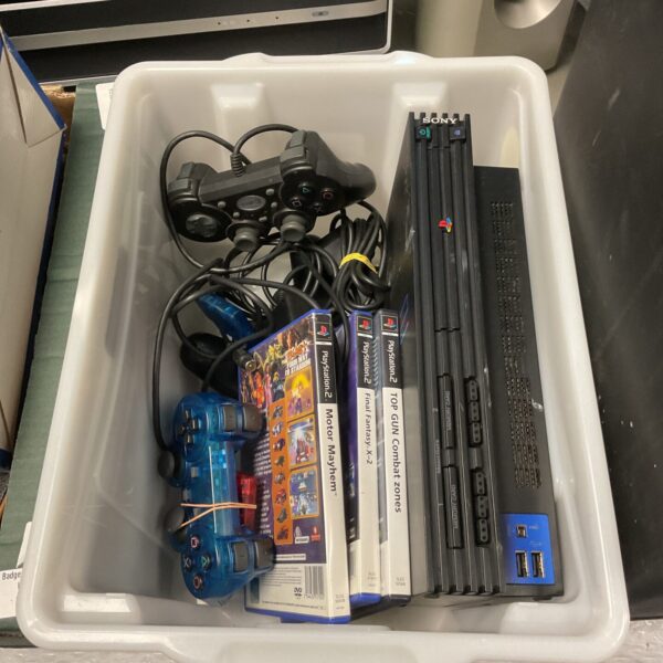 Sony PlayStation 2 console with controllers and games for retro gaming.