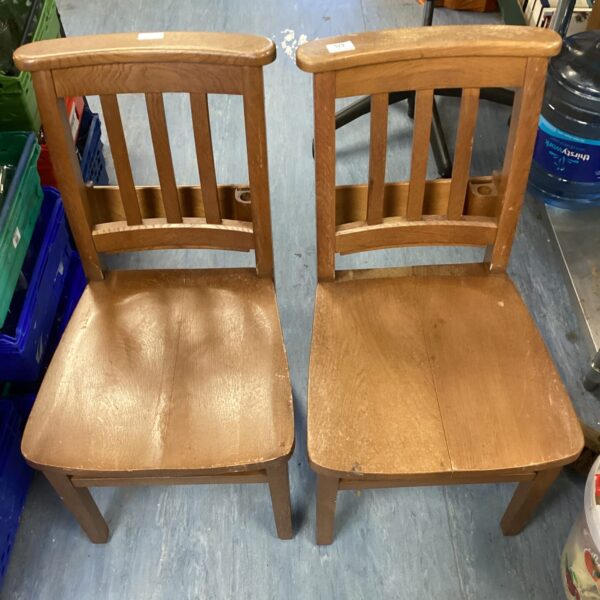 Pair of vintage mid-century oak chapel chairs with curved backs.