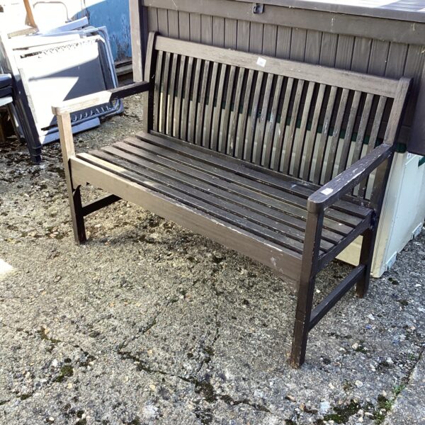 Weathered rustic wooden garden bench in a garden setting.