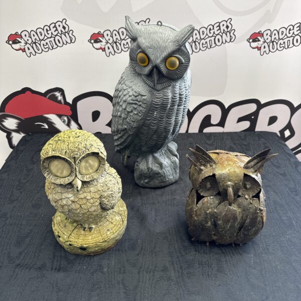 Collection of three garden owl ornaments in varying materials.
