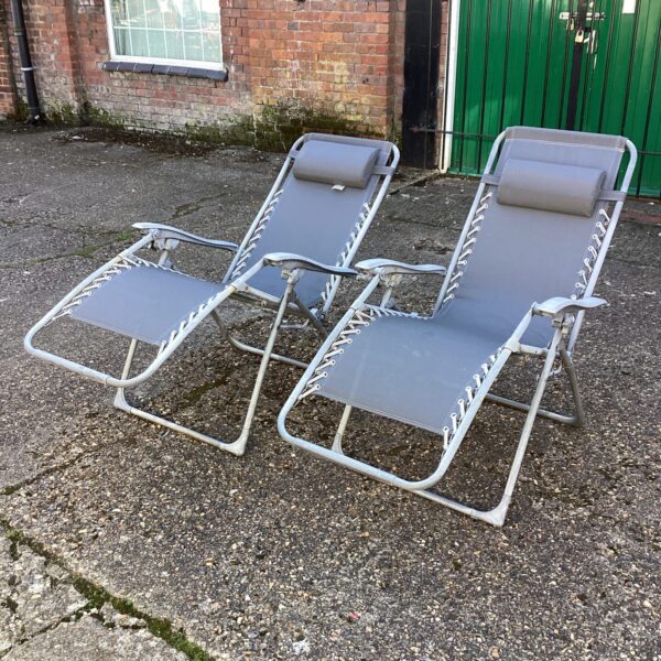 Pair of vintage sun loungers in a garden setting.