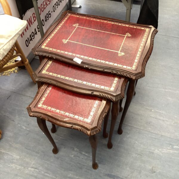 Vintage red leather nest of tables with mahogany legs.