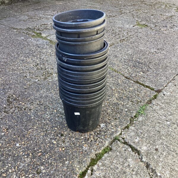 Stack of black plastic garden tubs for planting or storage.