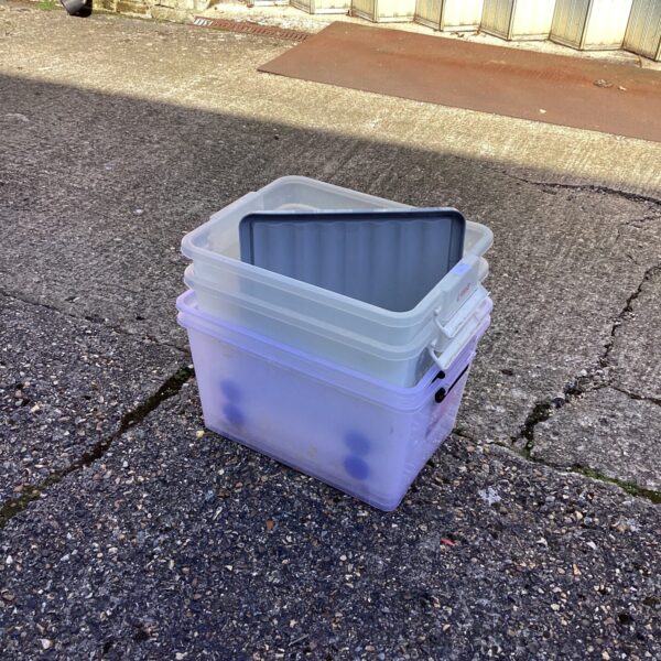 Lot of four plastic storage boxes for household organisation.