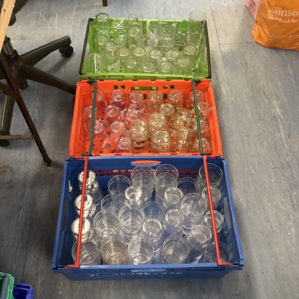 Three crates filled with mixed branded pub glasses.