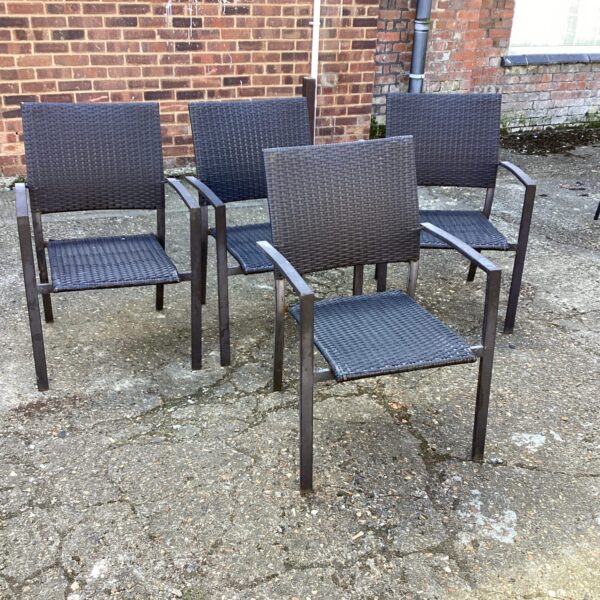 Four woven plastic garden chairs with black metal frames.