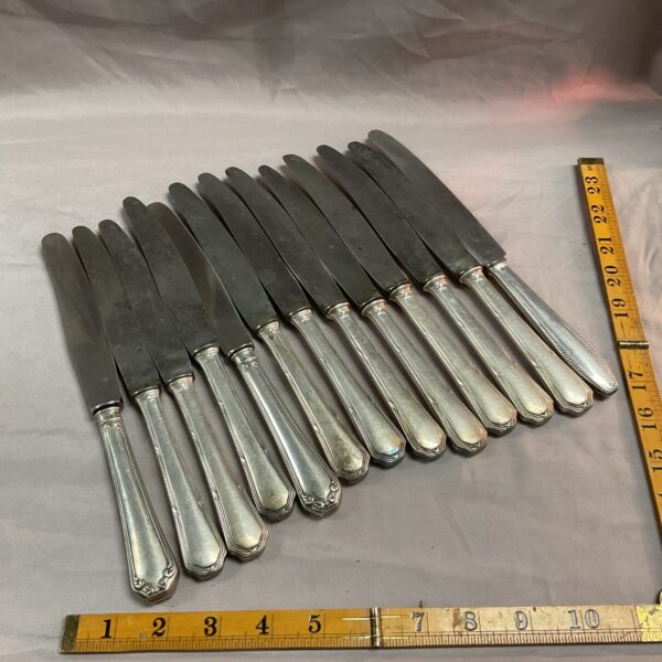 Lot of thirteen antique silver handle knives with engraved details.