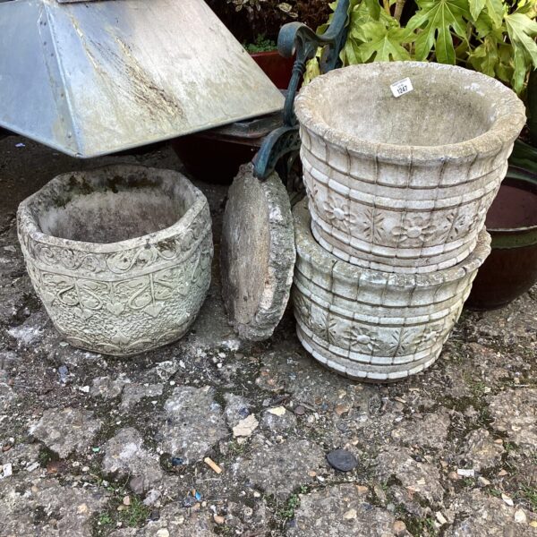 Three antique stone garden planters with embossed detailing.