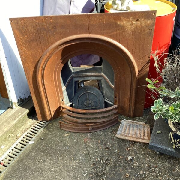 Antique cast iron fireplace insert with decorative detailing.