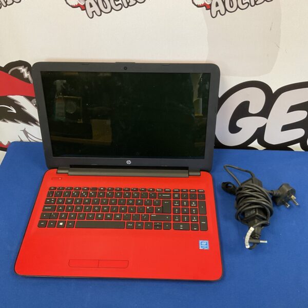 Red HP laptop with screen visible, showing a reflection.