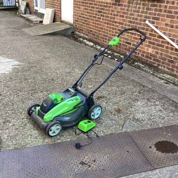 Greenworks 40V cordless lawn mower with spare battery and charger.