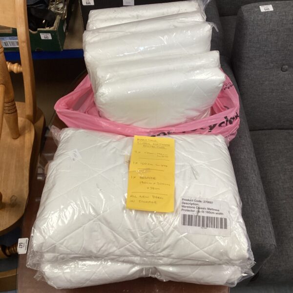 Stack of new Marston Classic mattress protectors in pink and white packaging.