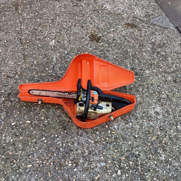 Stihl chainsaw in a hard plastic orange carrying case.