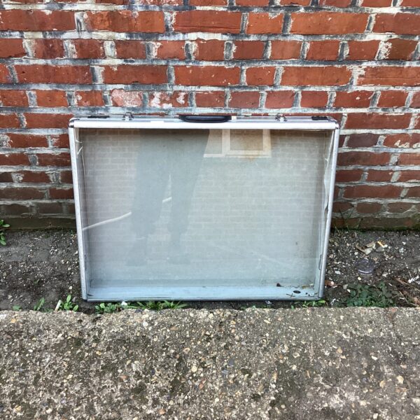 Vintage aluminium display case with glass front for collectibles.