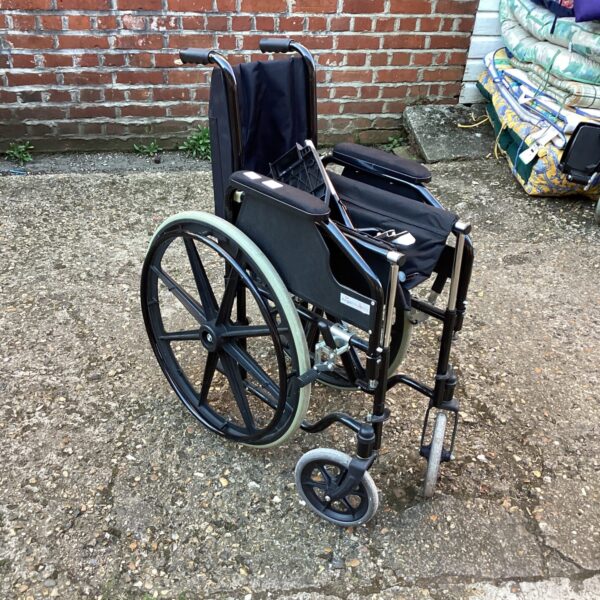 Side view of a used folding wheelchair, a mobility aid.