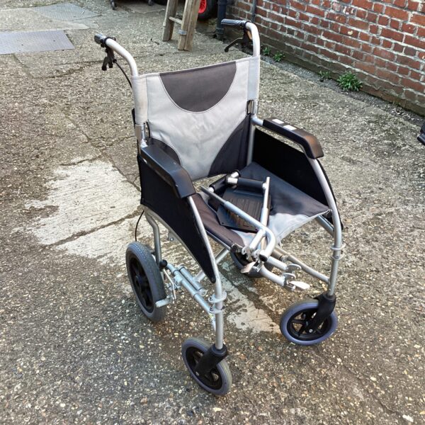 Grey folding wheelchair with padded seat and armrests.