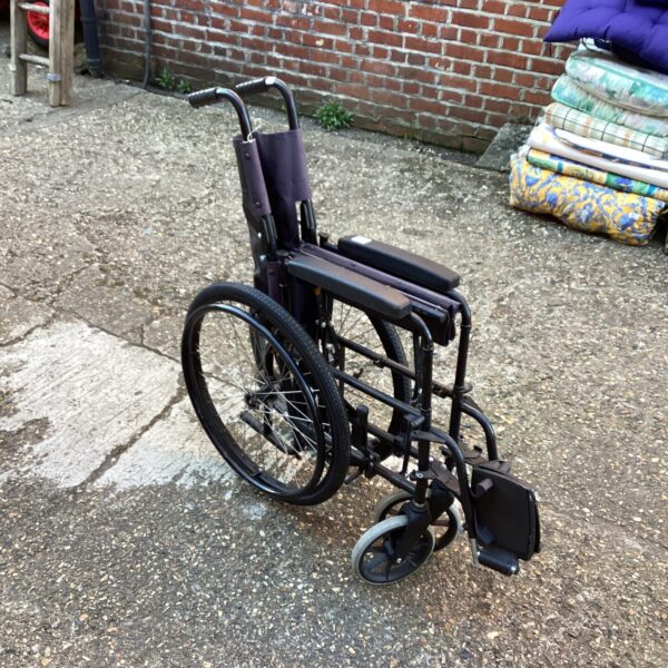 Side view of a used folding wheelchair, a practical mobility aid.