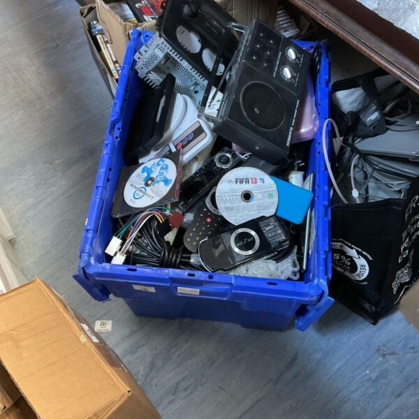 Crate filled with mixed gaming and IT equipment.