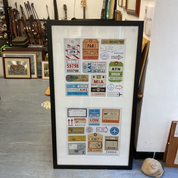 Framed vintage luggage tag art for retro travel decor.