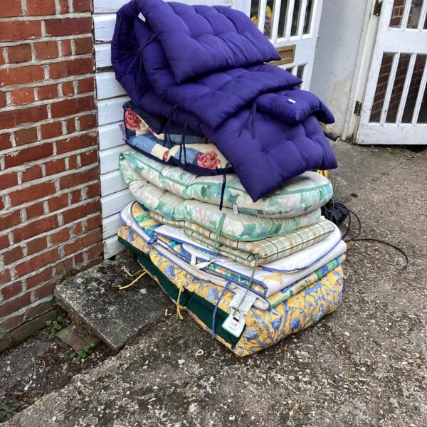 Large lot of floral sun lounger cushions for garden seating.