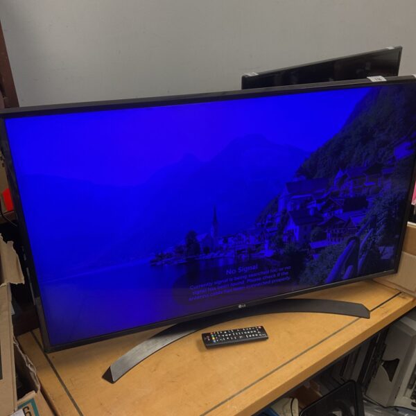 LG 43 inch HD TV with remote, dim screen visible.