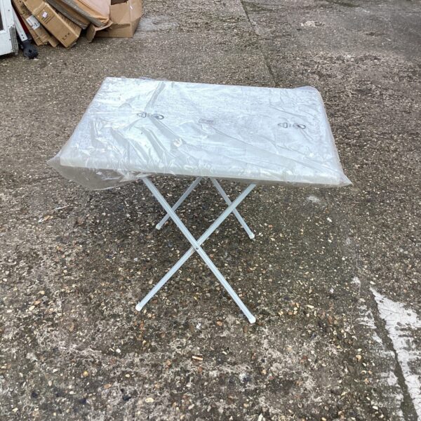 White plastic folding table in used condition, ideal for outdoor use.