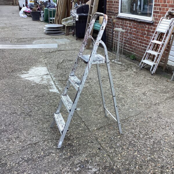 Side view of a vintage aluminium step ladder.