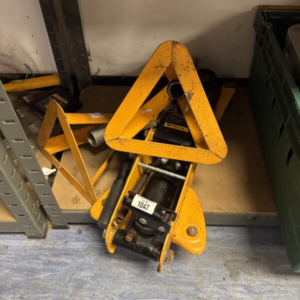 Red Halfords trolley jack for automotive repairs.