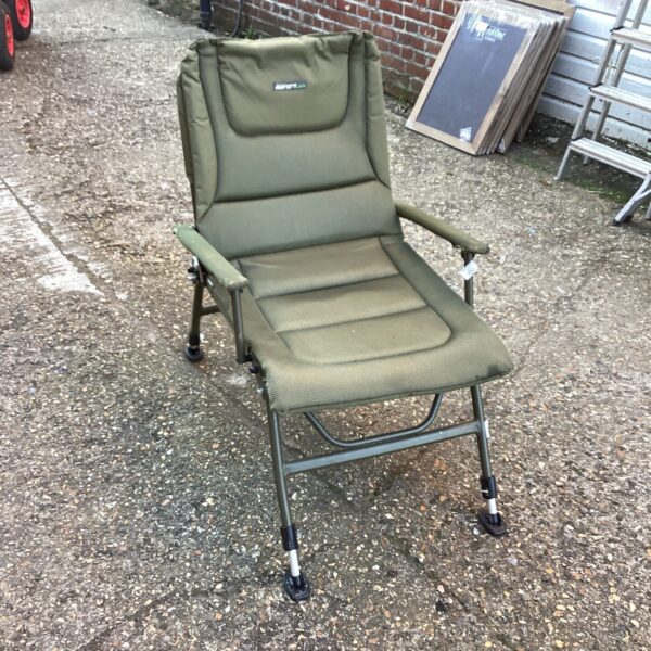 Green Korum fishing chair, folded and ready for angling.